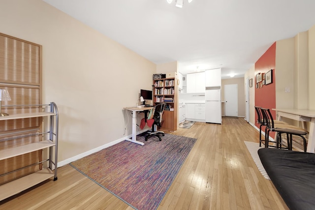 office with light wood-type flooring and baseboards