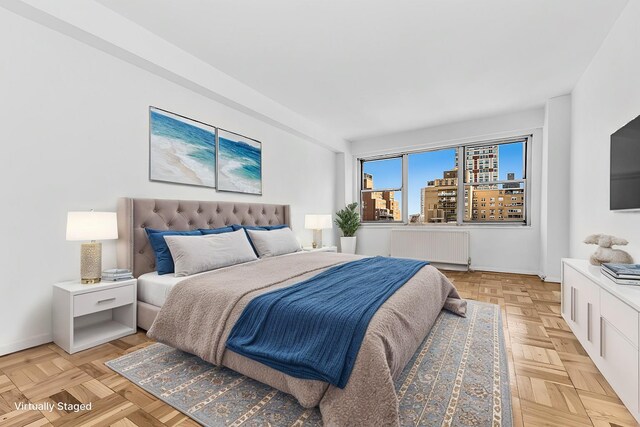 bedroom with radiator and light parquet floors