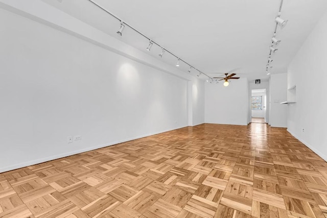 unfurnished living room with light parquet flooring, track lighting, and ceiling fan