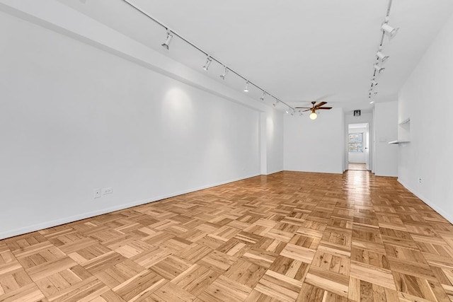 unfurnished room with baseboards, ceiling fan, and track lighting