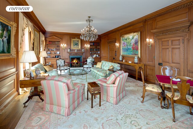 living room with ornamental molding, light hardwood / wood-style floors, and a chandelier