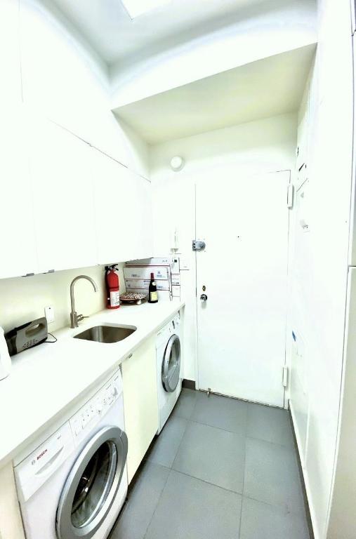 washroom with washer / clothes dryer, sink, dark tile patterned flooring, and cabinets