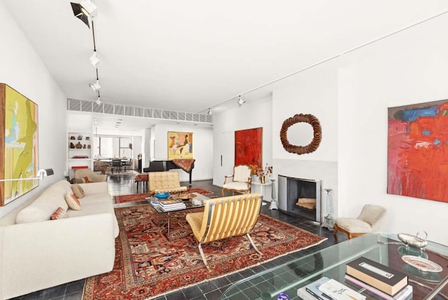 living room featuring a fireplace with flush hearth and rail lighting