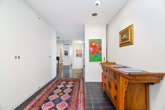 corridor featuring dark tile patterned flooring