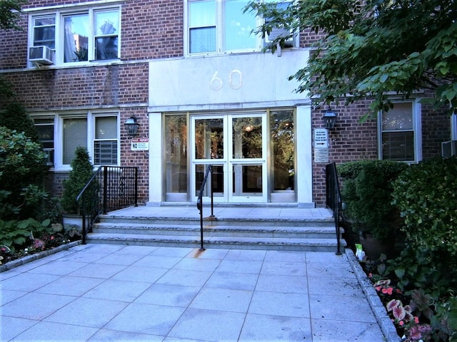 entrance to property with brick siding and cooling unit