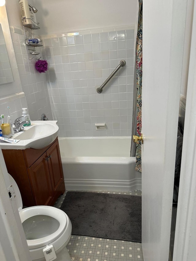 bathroom with tile patterned flooring, shower / bath combination, vanity, tile walls, and tasteful backsplash