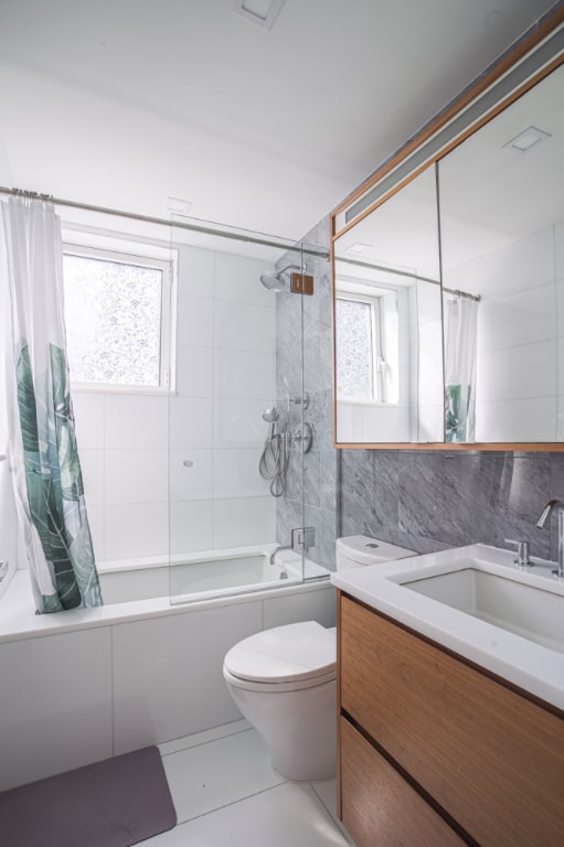 full bathroom featuring a wealth of natural light, tile walls, shower / tub combo, and vanity