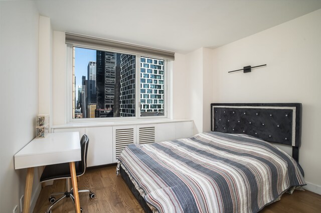 bedroom with dark hardwood / wood-style floors