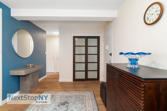 foyer featuring wood finished floors and baseboards