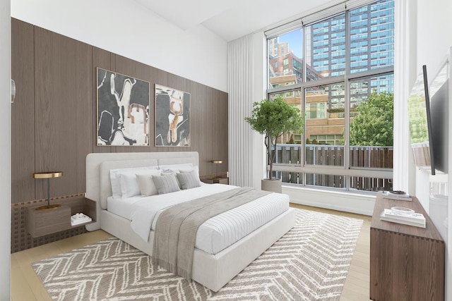 bedroom with wooden walls and light wood-type flooring