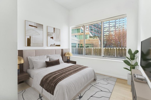 bedroom with baseboards and wood finished floors