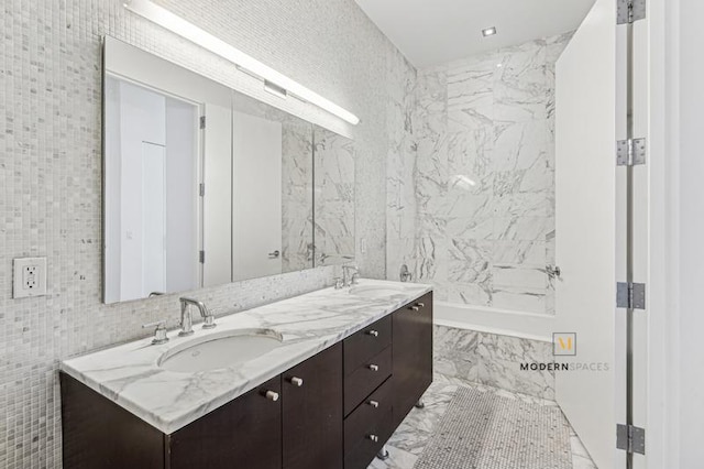 46-30 Center Blvd Unit 103, New York City, NY 11109 - full bathroom with tile walls, double vanity, a tub with marble appearance, and marble finish floors