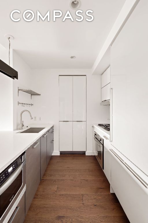 kitchen featuring sink, gas cooktop, stainless steel oven, and white cabinets