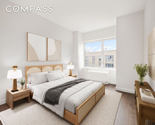 bedroom with wood-type flooring and baseboards