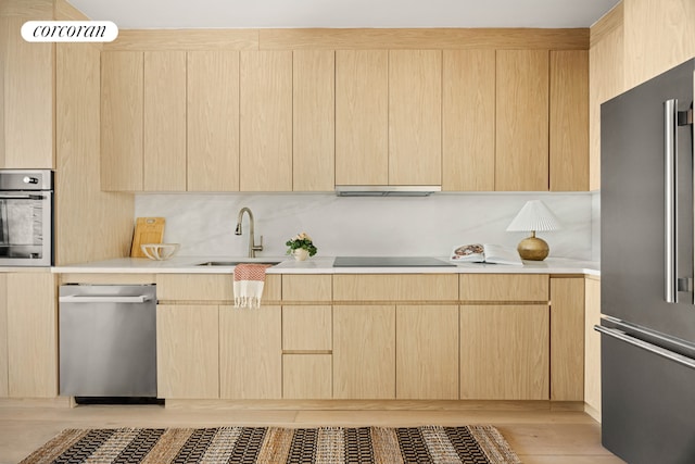 kitchen featuring appliances with stainless steel finishes, sink, light hardwood / wood-style flooring, and light brown cabinets