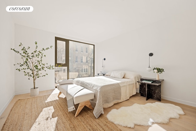 bedroom featuring visible vents, light wood-style flooring, and baseboards