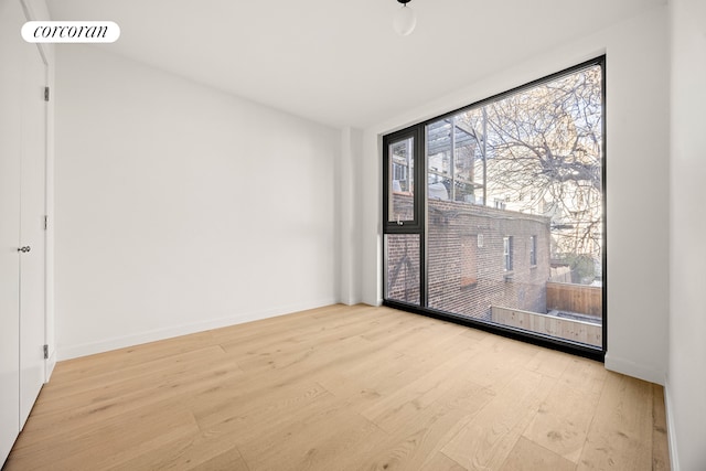 unfurnished room featuring visible vents, baseboards, and wood finished floors