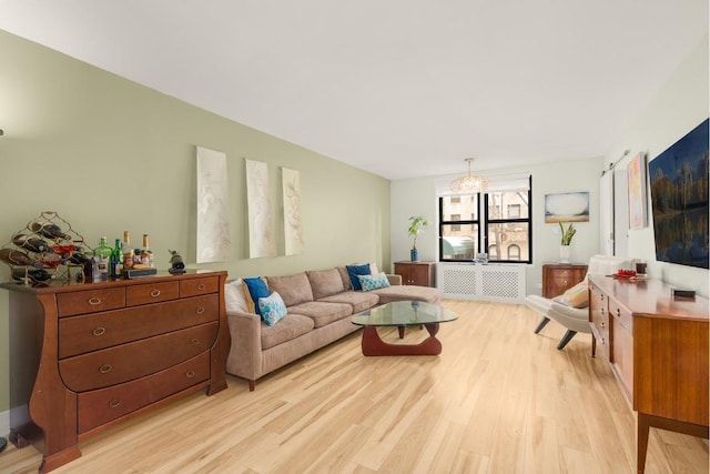 living room with a notable chandelier and light hardwood / wood-style floors