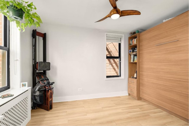 unfurnished room with ceiling fan, radiator, and light hardwood / wood-style floors