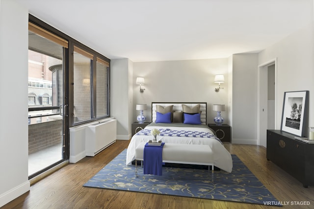 bedroom featuring baseboards, wood finished floors, and radiator