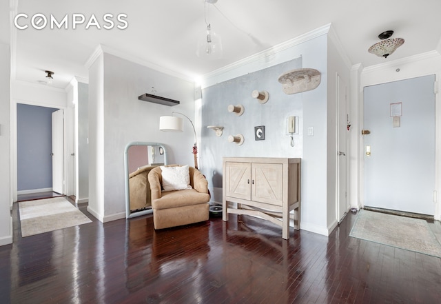 sitting room featuring ornamental molding, hardwood / wood-style flooring, and baseboards