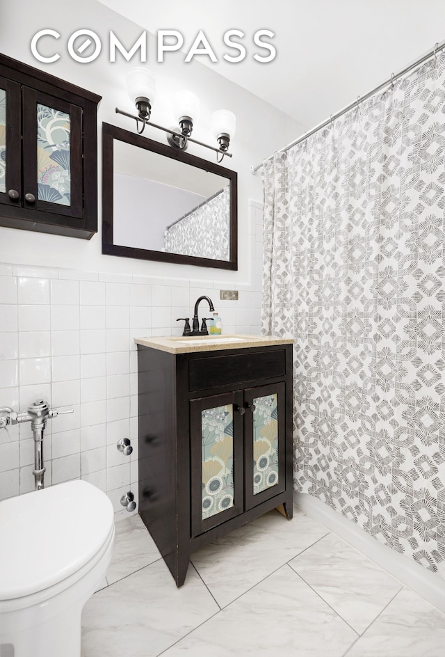 full bathroom featuring marble finish floor, tile walls, toilet, and vanity