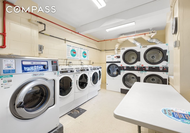 community laundry room featuring washing machine and clothes dryer, stacked washing maching and dryer, and tile patterned floors