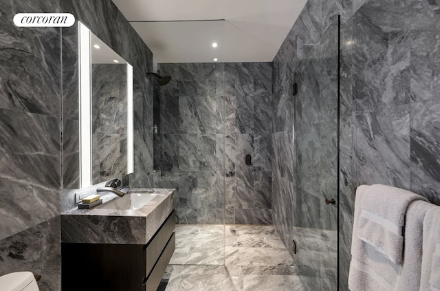 bathroom featuring vanity, toilet, tile walls, and a shower with shower door