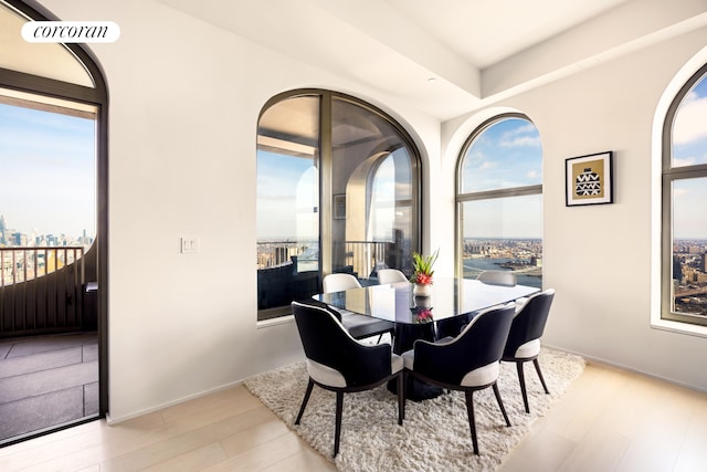 dining room with a city view, visible vents, baseboards, and wood finished floors