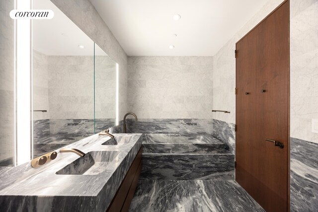 130 William St Unit Loggia59B, New York City, NY 10038 - bathroom with tile walls, marble finish floor, recessed lighting, and double vanity