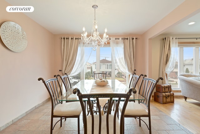 dining area featuring a chandelier, visible vents, baseboards, and stone tile flooring