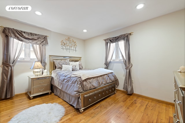 bedroom with light wood-style floors, visible vents, and multiple windows