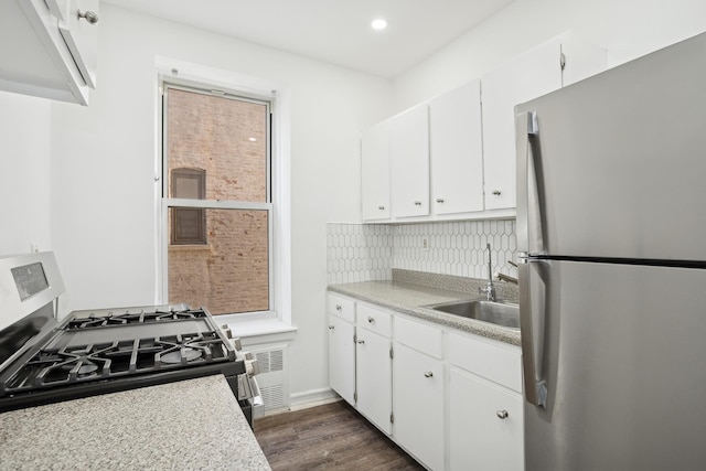 kitchen with stainless steel appliances, light countertops, white cabinetry, and a sink