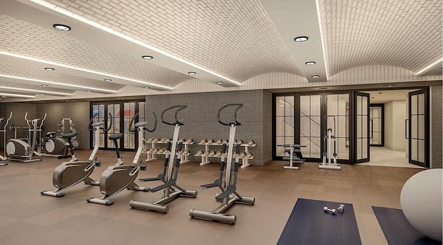 exercise room with lofted ceiling and brick ceiling