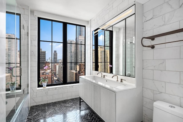 bathroom featuring a view of city, toilet, tile walls, and vanity