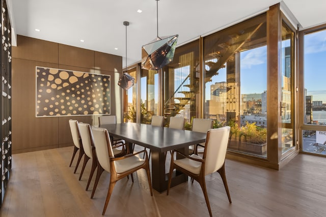 dining room with wood-type flooring and a wall of windows