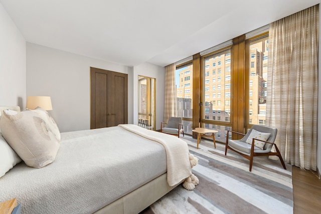 bedroom featuring wood-type flooring and floor to ceiling windows