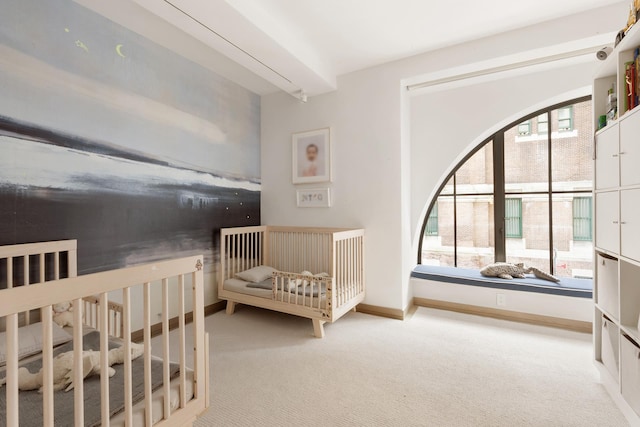 carpeted bedroom with arched walkways and baseboards