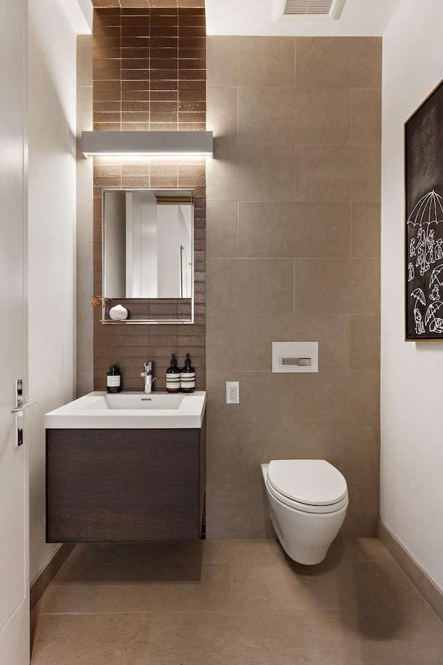 bathroom featuring toilet, baseboards, vanity, and tile patterned floors