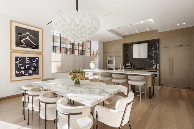 dining space with light wood-style flooring, recessed lighting, and baseboards