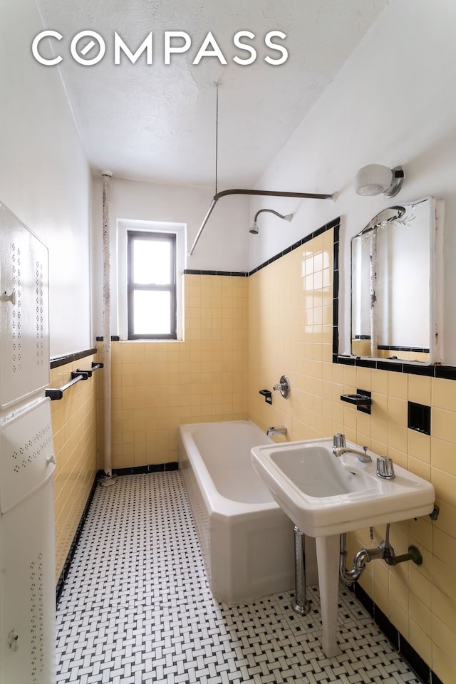 bathroom with tub / shower combination and tile walls