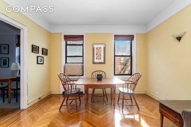 dining space with parquet flooring