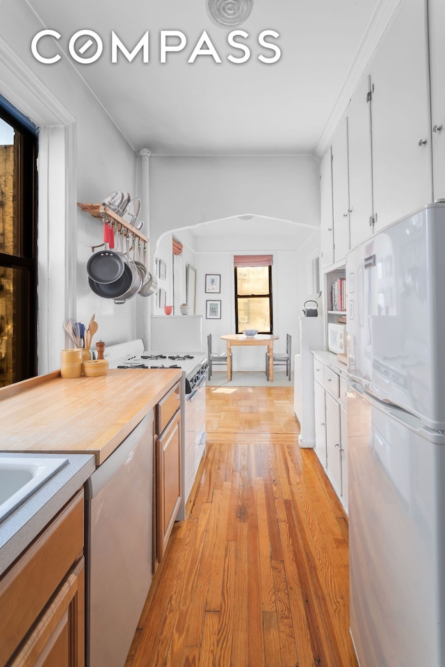 kitchen with white cabinetry, white appliances, light wood finished floors, and wood counters