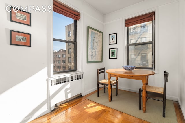 dining room with breakfast area, baseboards, and radiator