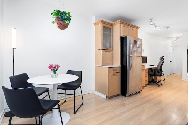 kitchen featuring rail lighting, light brown cabinetry, stainless steel refrigerator, and light hardwood / wood-style floors