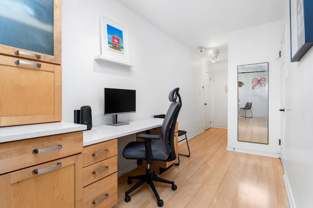 home office featuring light hardwood / wood-style flooring and rail lighting