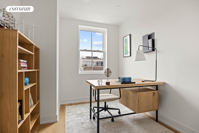 office space with baseboards and wood finished floors