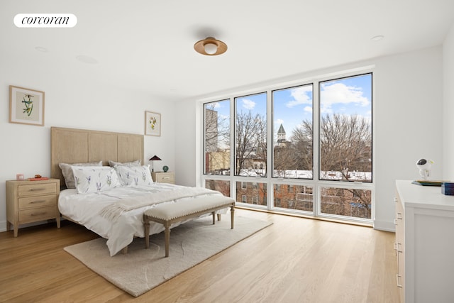 bedroom with visible vents, light wood-style flooring, and expansive windows