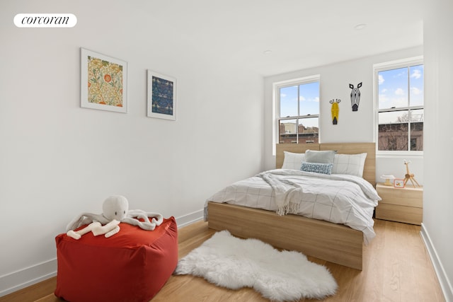 bedroom with visible vents, baseboards, and wood finished floors