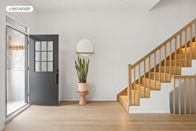 foyer entrance with stairway, wood finished floors, visible vents, and baseboards